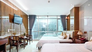 Een hotelkamer met twee bedden, een bureau en een aan de muur bevestigde televisie.