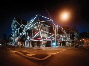 A modern building with geometric light installations at night.