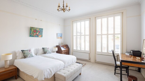 A bedroom with two beds, a desk, and a chair. - Courtside Charms, by Veeve (London)