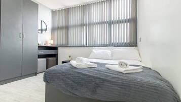 Desk, iron/ironing board, bed sheets