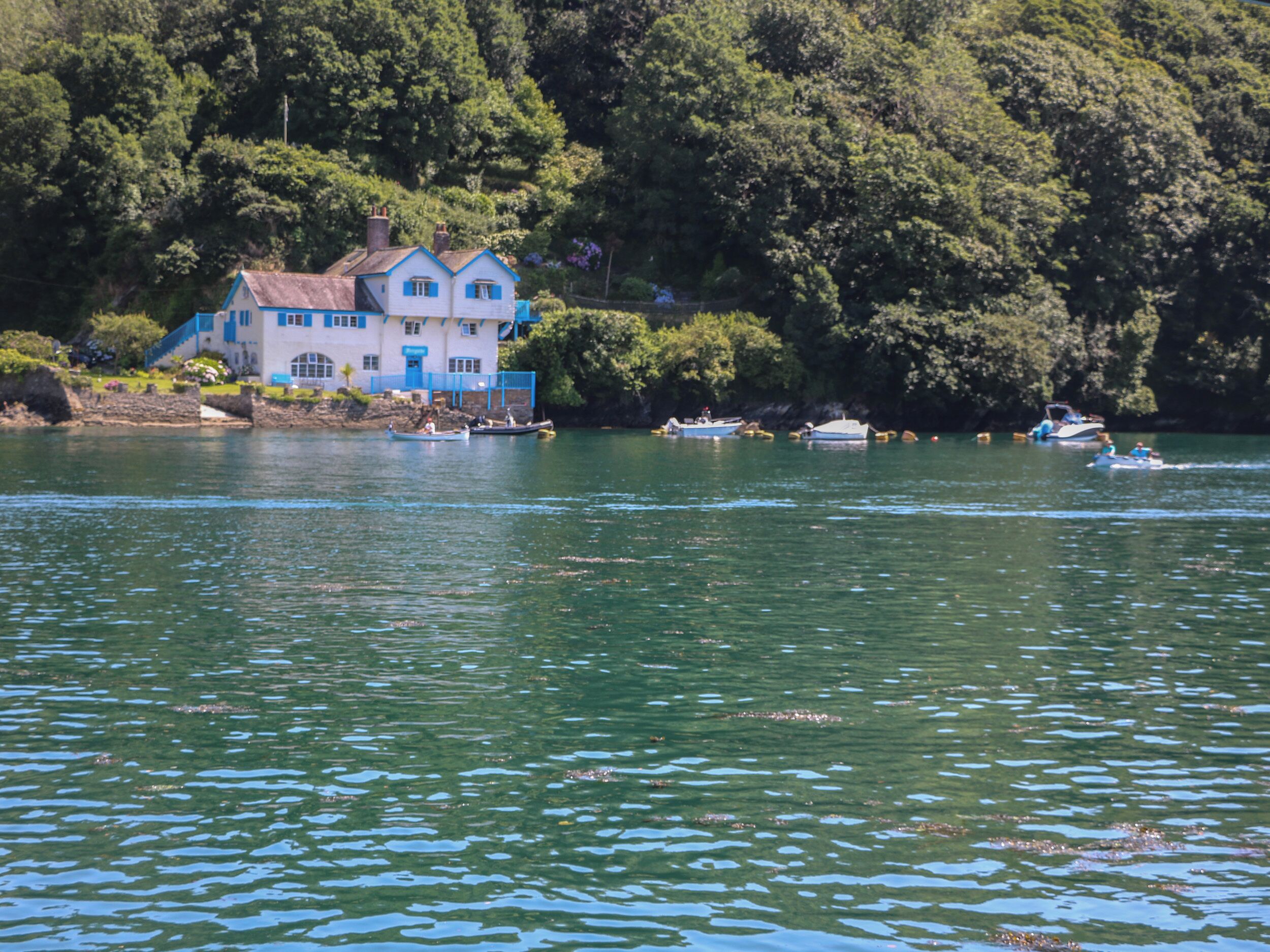 Ein Haus am See mit Booten und einer Anlegestelle.