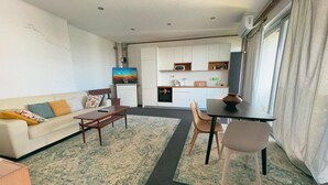 A compact living space with a sofa, a dining table, and a kitchen area.
