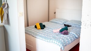 A single bed with a patterned bedspread, a bedside table, and a wall-mounted light.
