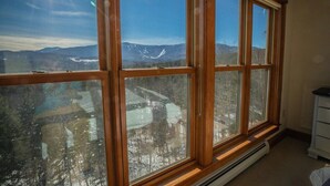 A room with large windows offering a view of a snowy landscape and mountains. - Vermont Post & Beam w/Hot Tub & Stunning Views (Waitsfield)