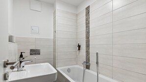 Ein modernes Badezimmer mit Waschbecken, Badewanne und Dusche.