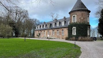 Stately building with a prominent tower and a well-manicured lawn.