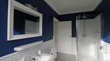 A bathroom with a white sink, mirror, and shower.