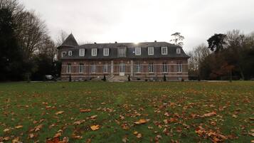 A large, historic building with a symmetrical facade, multiple windows, and a central entrance.