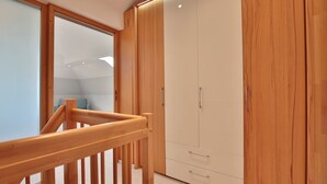 A modern room with wooden furniture, a glass door, and a staircase. - Haus Schäfer Appartement 8 (Timmendorfer Strand)
