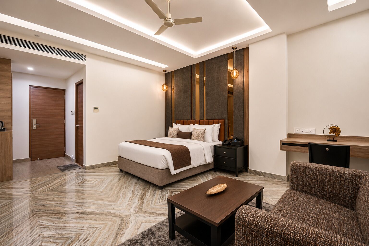 Una habitación de hotel moderna con cama, mesita de noche, silla, escritorio y ventilador de techo.