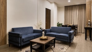 Una sala de estar moderna con dos sofás, una mesa de centro y un comedor con mesa y sillas.