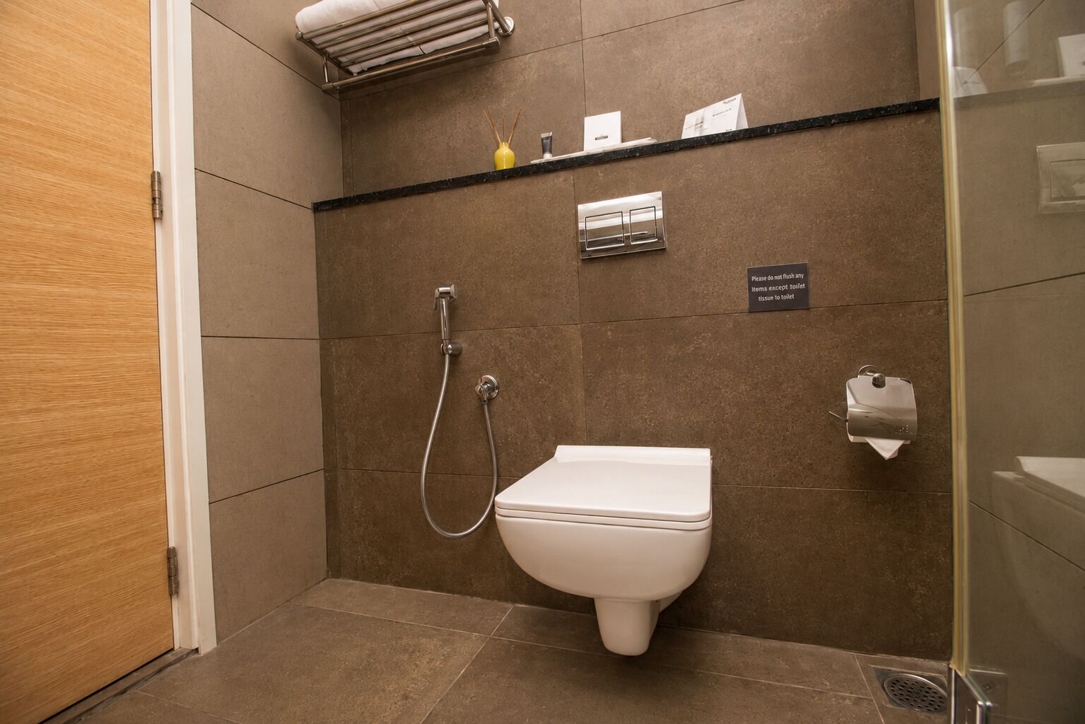 A modern bathroom with a shower, toilet, and hand dryer.