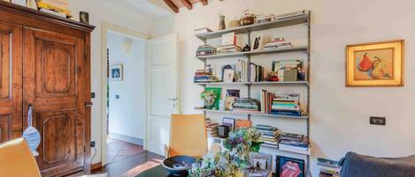 A cozy living room with a wooden cabinet, a bookshelf, and a framed picture on the wall.