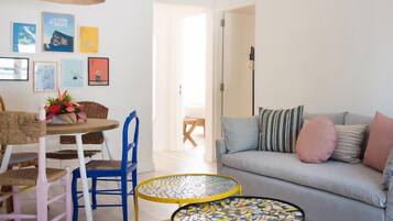 A living room with a sofa, a dining table with chairs, and a coffee table.