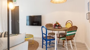 A modern living room with a sofa, a round table, and wicker chairs. - Dodo Square (Grand-Baie)