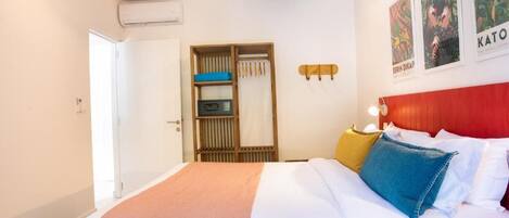 A bedroom with a bed, a wardrobe, and a red headboard.