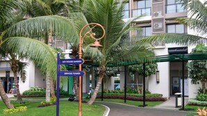 Un panel con indicaciones hacia 'Sky House Garden' y 'Jervis Tower' frente a un edificio moderno con entrada cubierta.