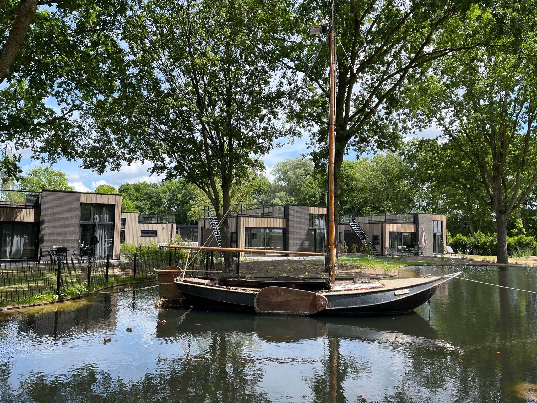 A modern building with a dock and a sailboat.