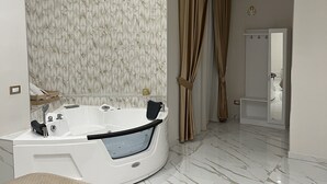 Ein modernes Badezimmer mit einer freistehenden Badewanne, einem an der Wand montierten Flachbildfernseher und einer Duschkabine.