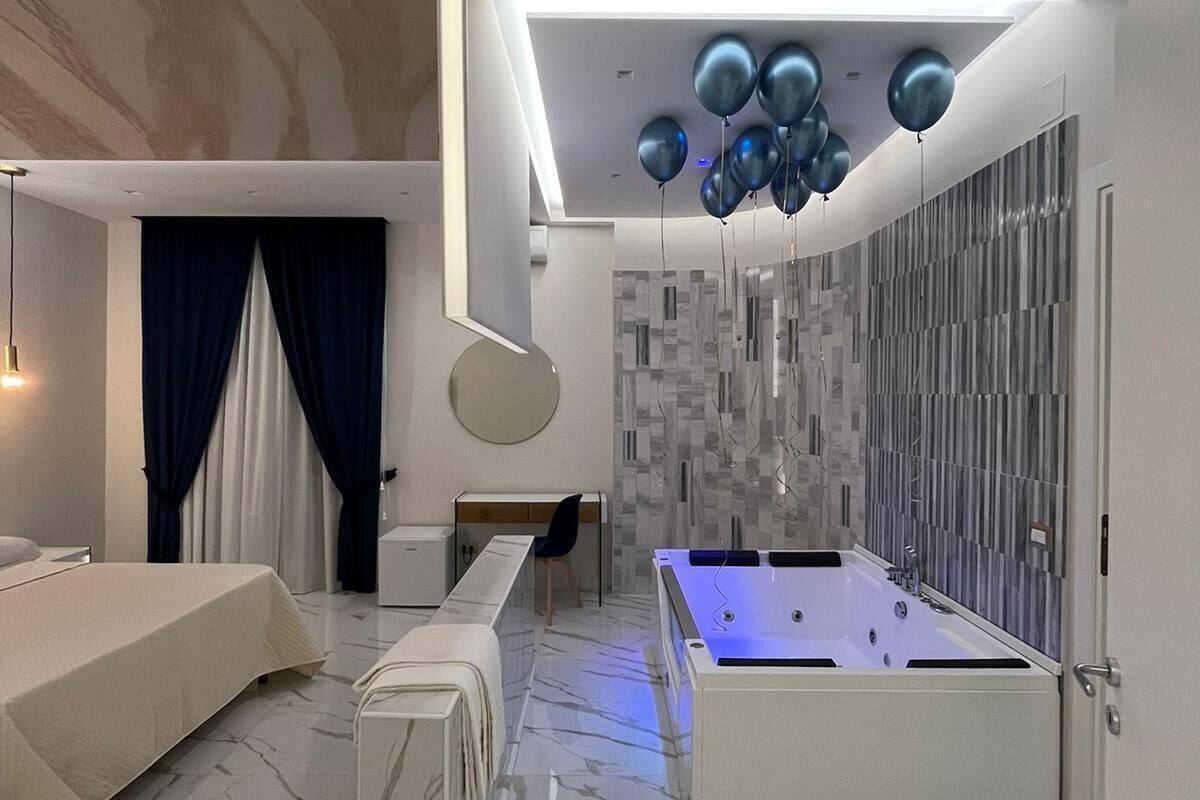 A modern bedroom with a large bed, a desk, and a pool table.