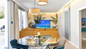 Un espace repas moderne avec une table en verre, des chaises bleues et un canapé.