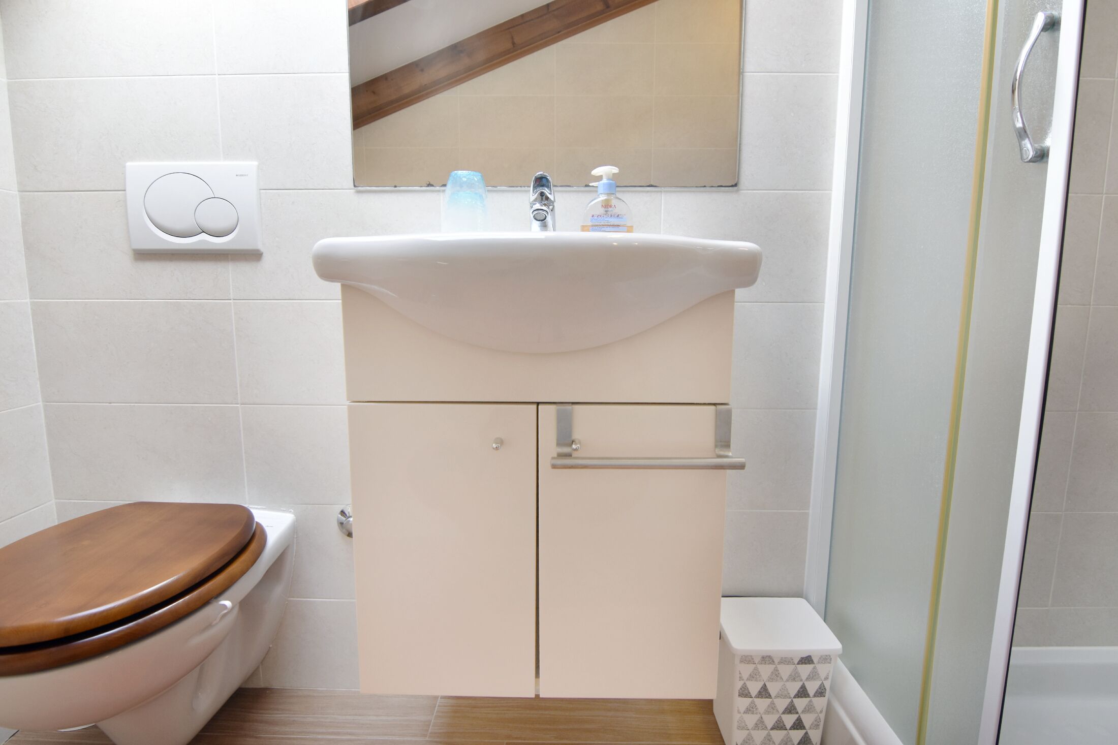 Une salle de bain avec des toilettes, un lavabo et une douche.
