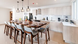 A modern kitchen with a central island, wooden cabinets, and pendant lighting. - La Vista #B10, amazing Views - Brand New 3 bd Condo overlooking Tamarindo Bay Vista B-10 (Tamarindo)