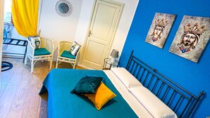 A bedroom with a bed, a chair, a desk, and a window with curtains. - Panoramic Taormina Center (Taormina)