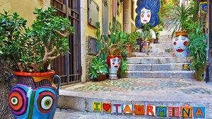 A staircase with colorful tiles spelling "IOTAORMENA" and potted plants on the steps. - Panoramic Taormina Center (Taormina)