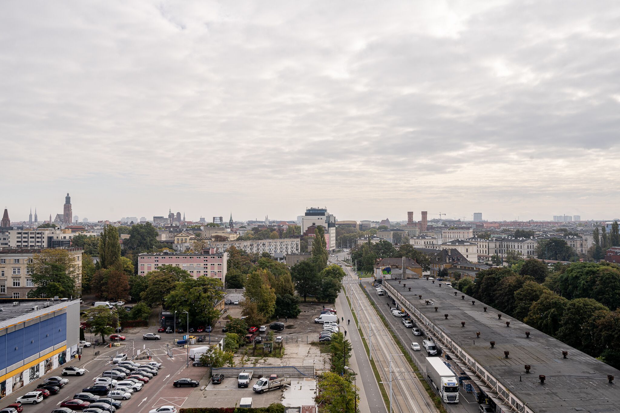 Une vue urbaine comprenant un grand parking et une autoroute.
