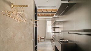A modern kitchen with a wooden floor, built-in appliances, and a hanging rack for utensils. - Luxury apartment in Trastevere (Roma)