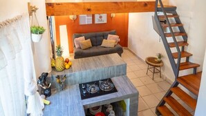 A modern interior with a kitchen area, a dining table, and a staircase. - Best Location in Sayulita - Walk to Everything (Sayulita)