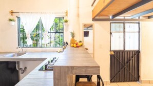 A kitchen with a wooden countertop, a sink, and a window with curtains. There are fruits and a plant on the counter. - Best Location in Sayulita - Walk to Everything (Sayulita)
