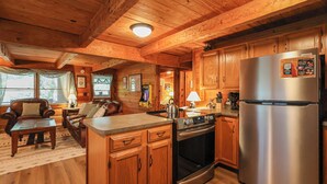 L’intérieur d’un chalet en bois comprend une cuisine, un coin repas et un salon.