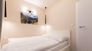 Quarto com cama, quadro na parede e porta.