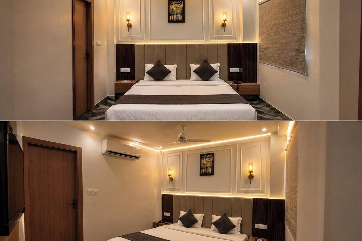 A hotel room with a large bed, wall-mounted lights, and a ceiling fan.