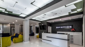 Un área de recepción con mostrador, televisor y un letrero que dice "RECEPTION".