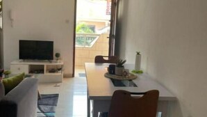 A compact living space with a dining area, a TV, and a small kitchenette. - Cheb's House (Abidjan)