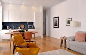 Ein moderner Wohnraum mit Küche, Essbereich und einer gemütlichen Sitzecke mit Sofa und Sesseln.
