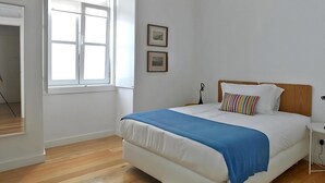 A bedroom with a bed, a window, and two framed pictures on the wall. - Alfama Prime II by Homing (Lisbon)