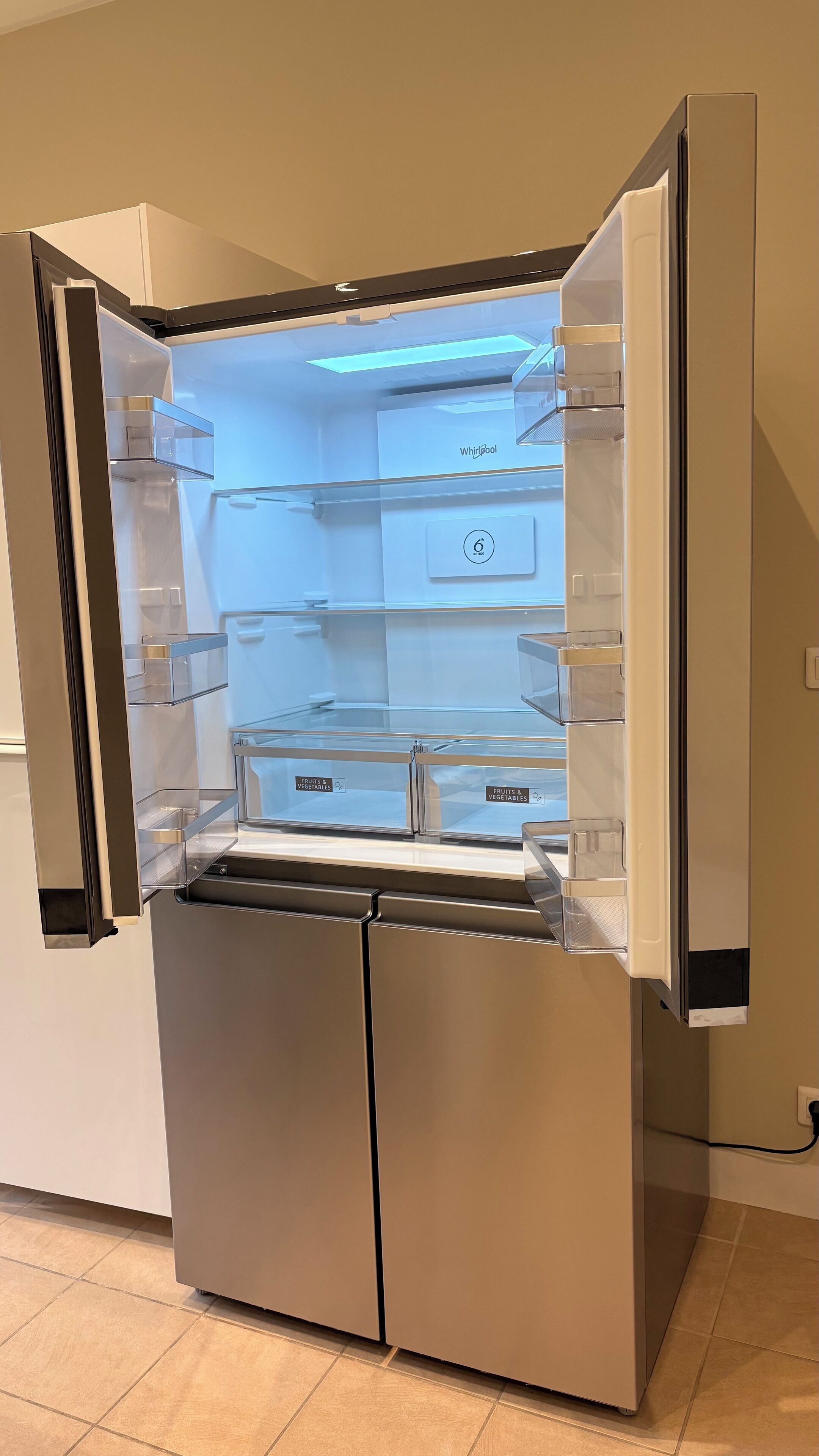 Un refrigerador de acero inoxidable con puerta transparente, panel de control e deshiela incorporado.