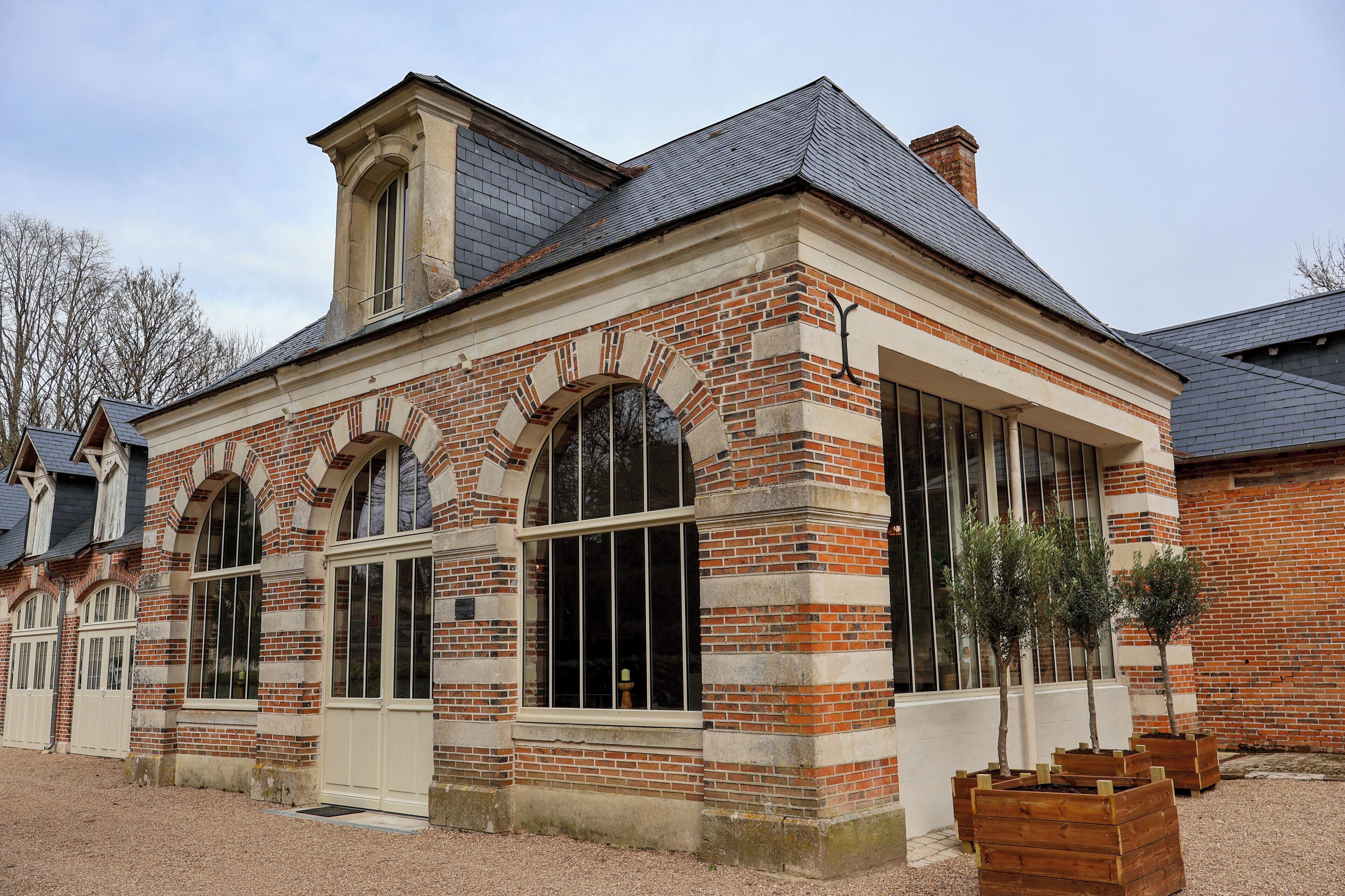 A brick building with large arched windows and a small tower.