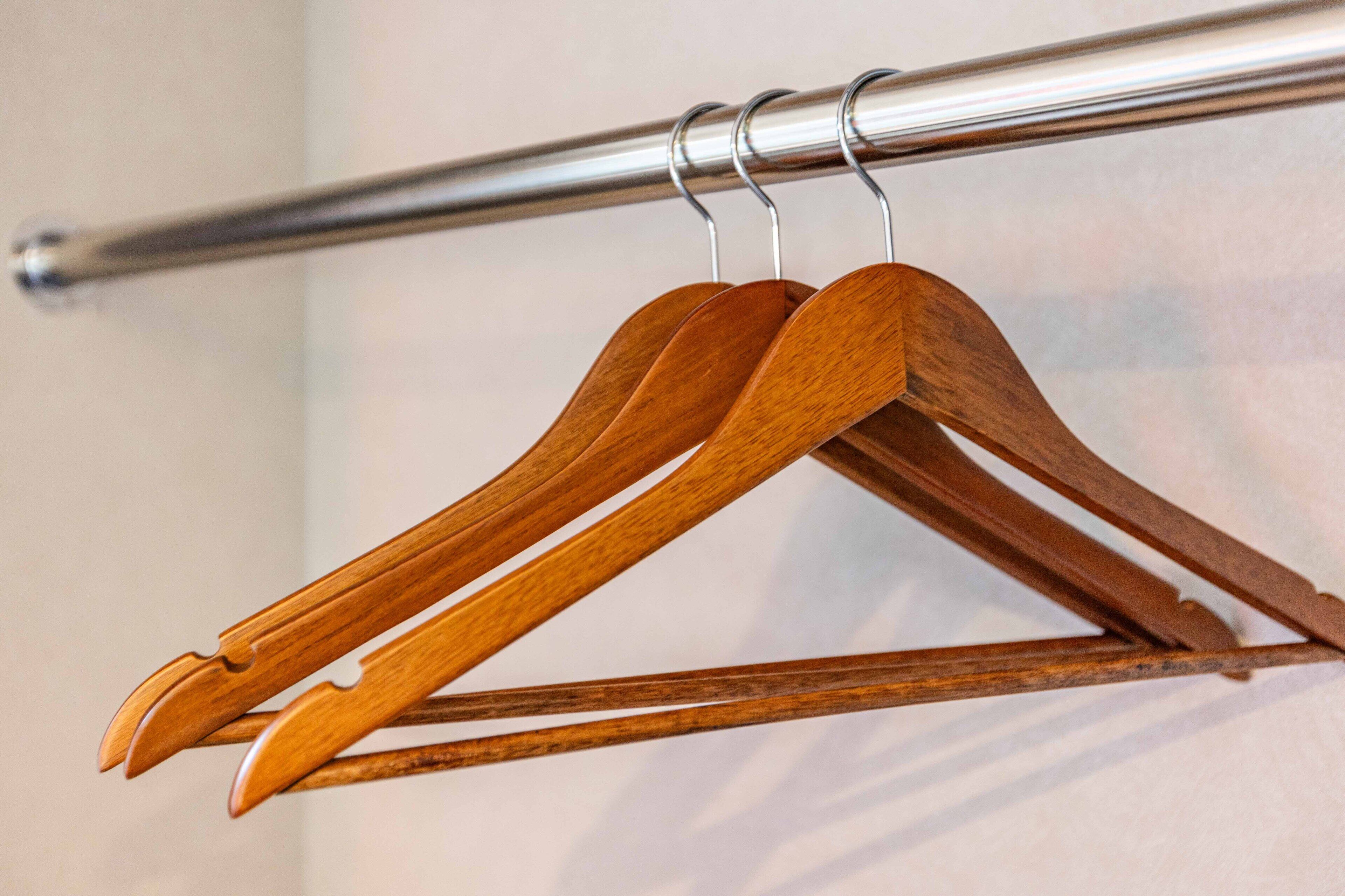 A metal rod with wooden hangers attached to it.