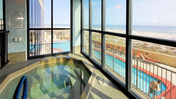 A hot tub with a view of a beach and pool area. - Beachfront 1BR @ Phoenix III • Sleeps 4 • Stunning Views, Balcony, Pools & Beach Access (Orange Beach)