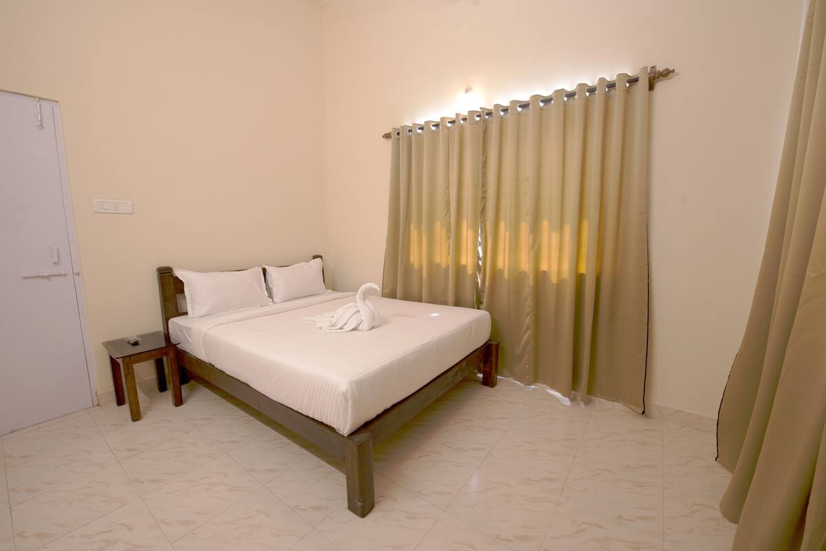 A neatly made bed with a swan pillow and a small bedside table.