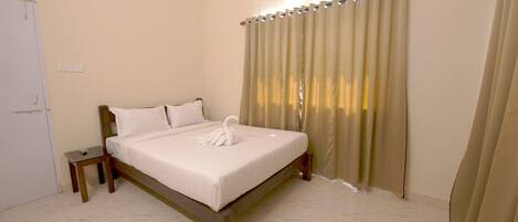 A neatly made bed with a swan pillow and a small bedside table.