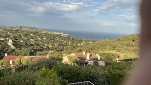 A coastal town with terraced houses, a view of the sea, and a prominent church. - Xxxxxxxxxx (Sainte-Maxime)