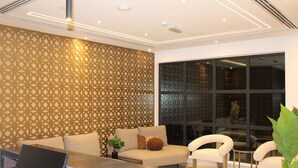 A modern interior with a sofa, two armchairs, a small table, and a decorative wall panel. - DUQM EXPRESS (Duqm)