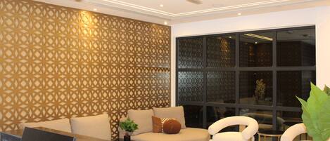 A modern interior with a sofa, two armchairs, a small table, and a decorative wall panel.