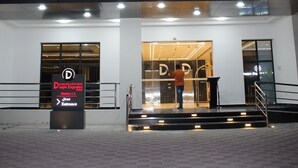 The exterior of Duqm Express Hotel with a sign indicating the entrance and a person standing on the stairs. - DUQM EXPRESS (Duqm)